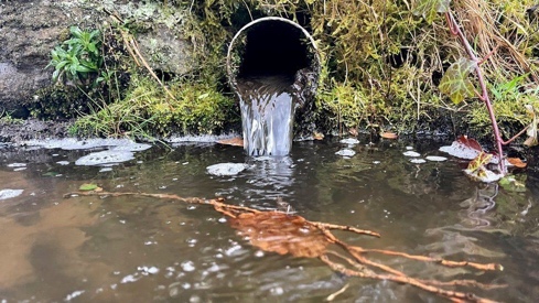 A pipe with water flowing out of it

Description automatically generated