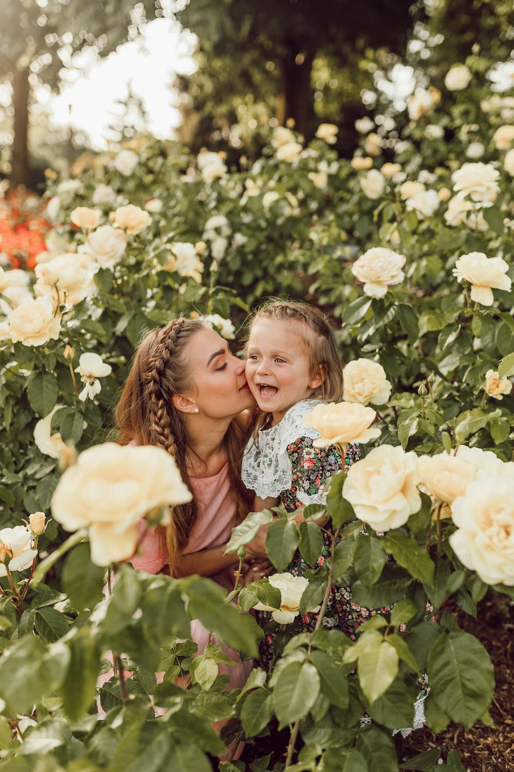 mother playing with her child in field of flowers