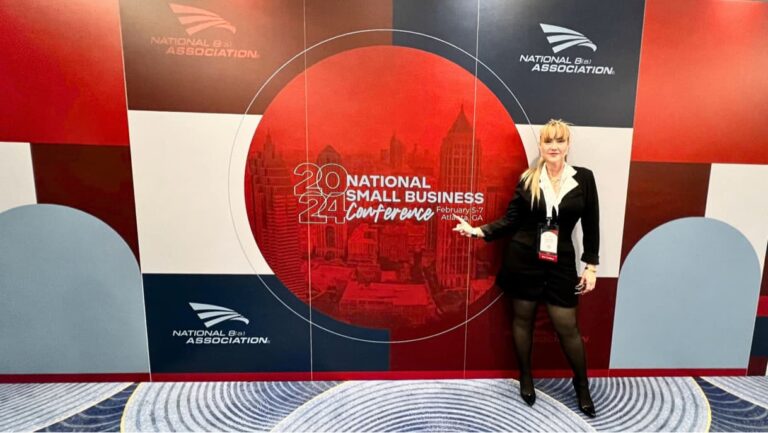 Lynette in front of National small business conference sign