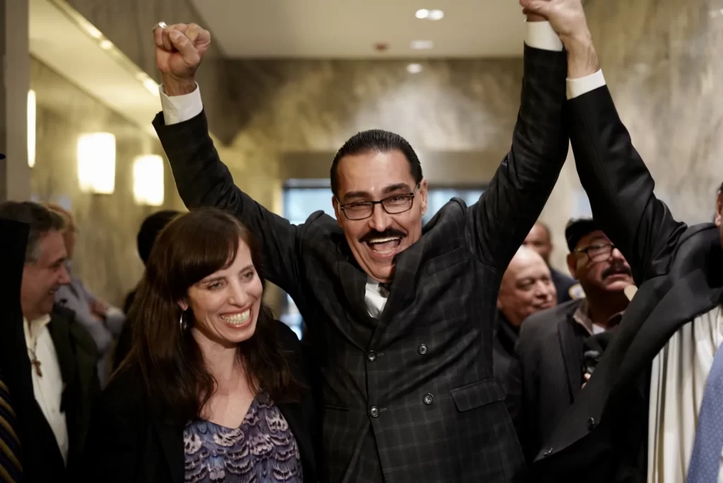 Innocence Project man celebrating with hands raised up in air