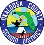 Logotipo del distrito escolar del condado de Okaloosa. Presenta el contorno de Florida, una lámpara del conocimiento, un libro, un birrete de graduación y rayos de luz. El círculo exterior es azul con texto blanco.