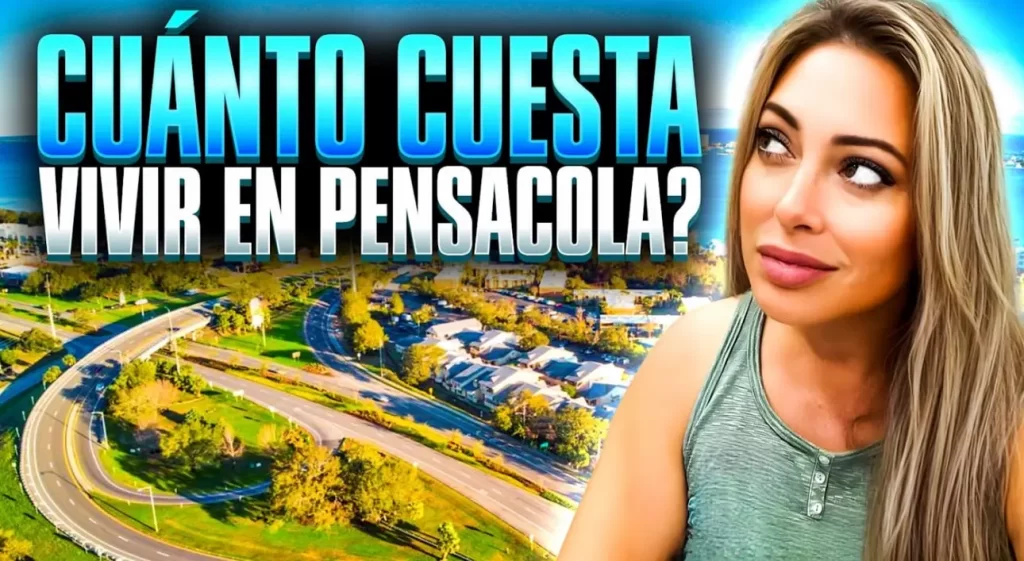 Text reads "CUÁNTO CUESTA VIVIR EN PENSACOLA?" in bold letters. An aerial view of a scenic landscape with roads, trees, and houses unfolds like a journey. A person with long hair is looking to the right, wearing a sleeveless top in the foreground, as if capturing their adventure for YouTube.