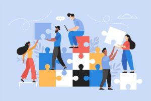 Ilustración de seis personas colaborando para construir una estructura con grandes piezas de puzzle de colores. Una persona trabaja en un ordenador portátil encima de los bloques, mientras los demás levantan, manipulan o colocan juntas las piezas del puzle.