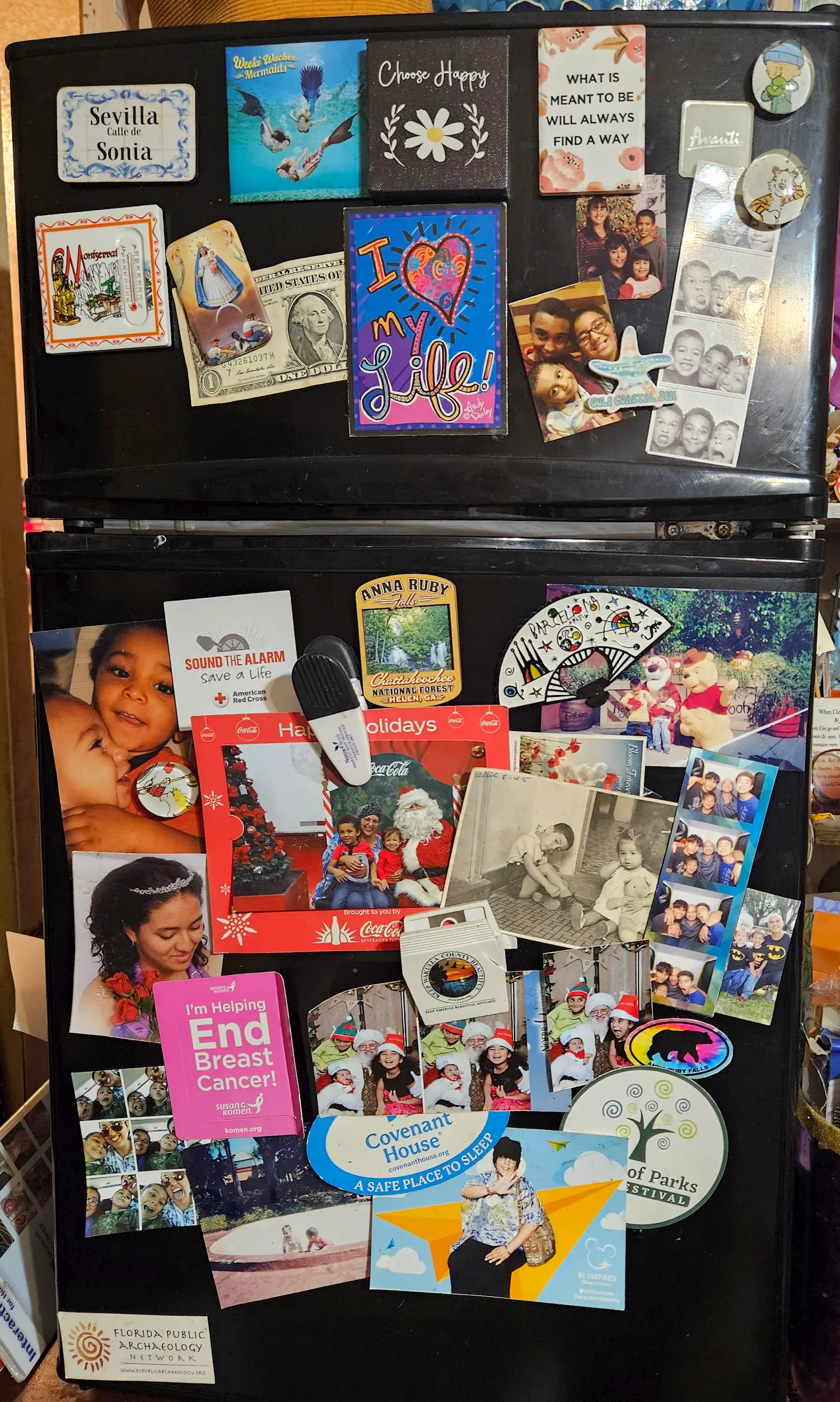 A refrigerator covered with colorful magnets, postcards, family photos, and stickers, including holiday cards, inspirational quotes, and various event reminders, creating a busy and personal collage.